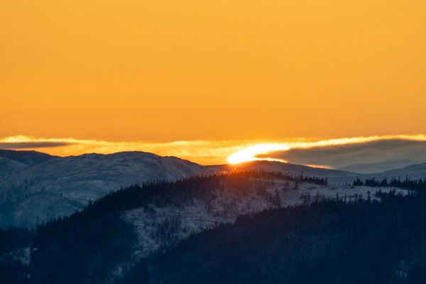 Icy mountain peak glowing under soft blue light